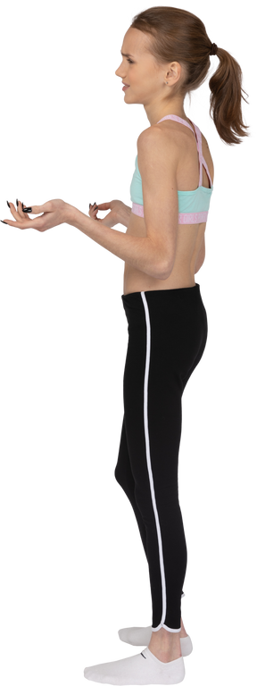 Vista lateral de una jovencita disgustada en ropa deportiva levantando las manos