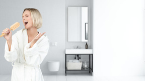 Mujer en bata de baño cantando en cepillo para el cabello