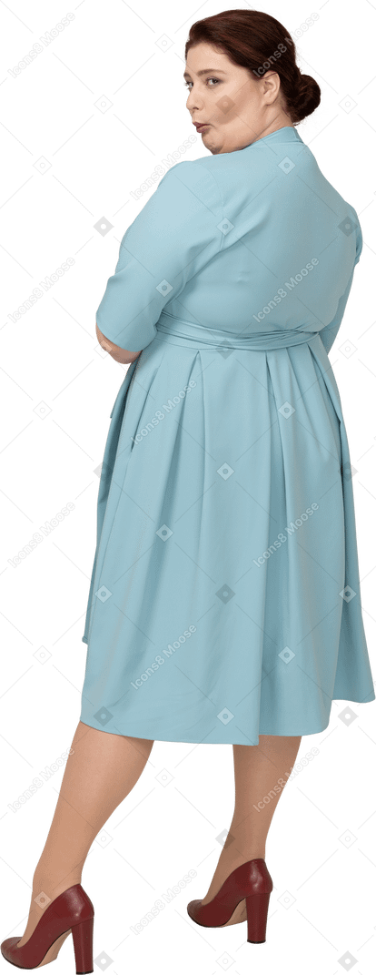 Vue arrière d'une femme en robe bleue faisant des grimaces