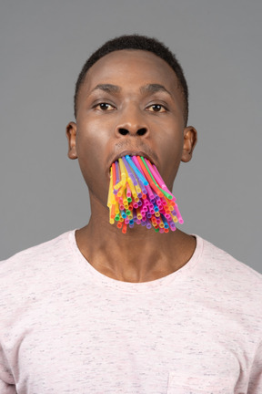 Young man with a bunch of straws in his mouth
