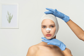 Female patient with gloved hands above and below her face