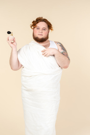 Big guy wrapped in towel applying perfume