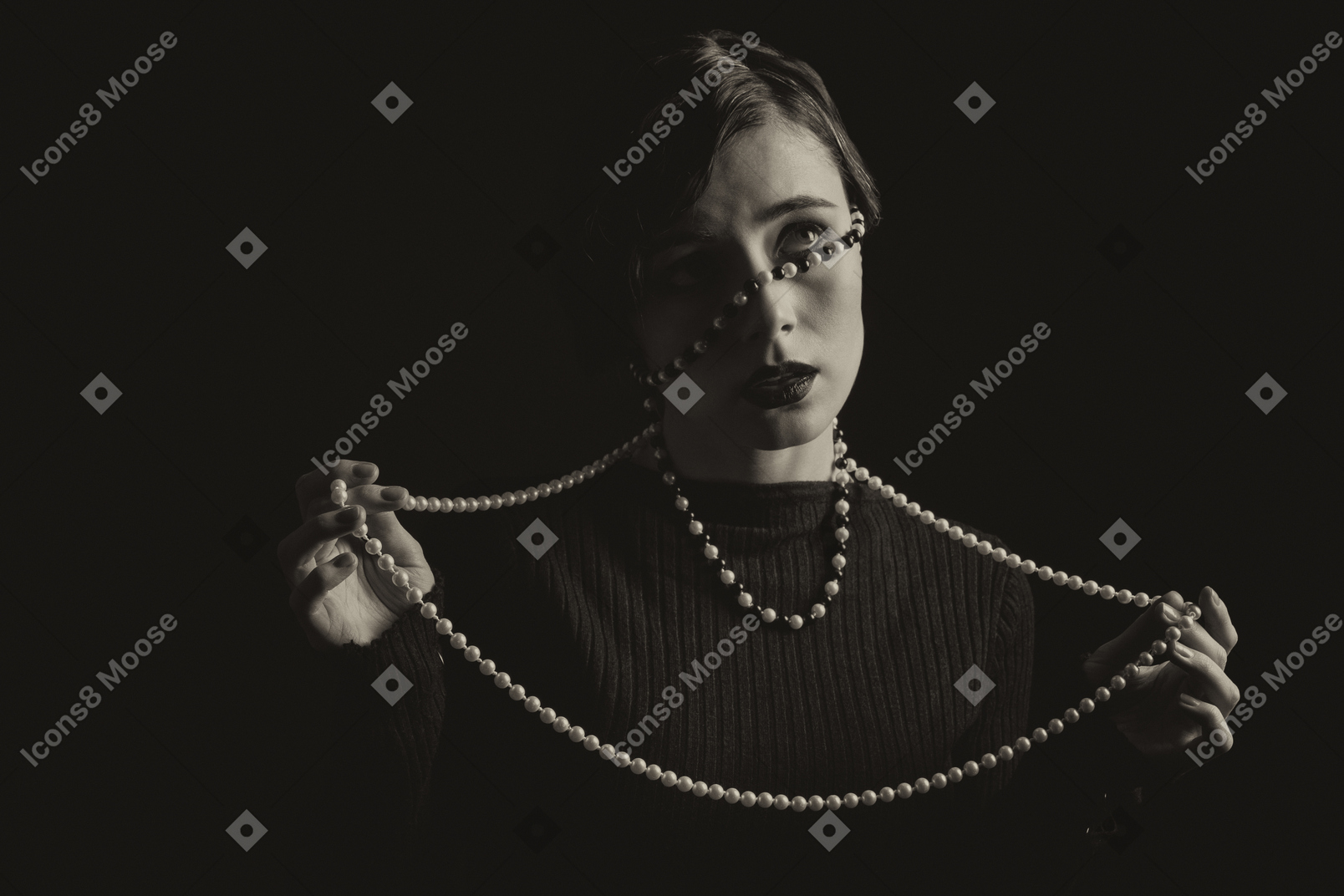 Femme dans le noir enveloppé de perles