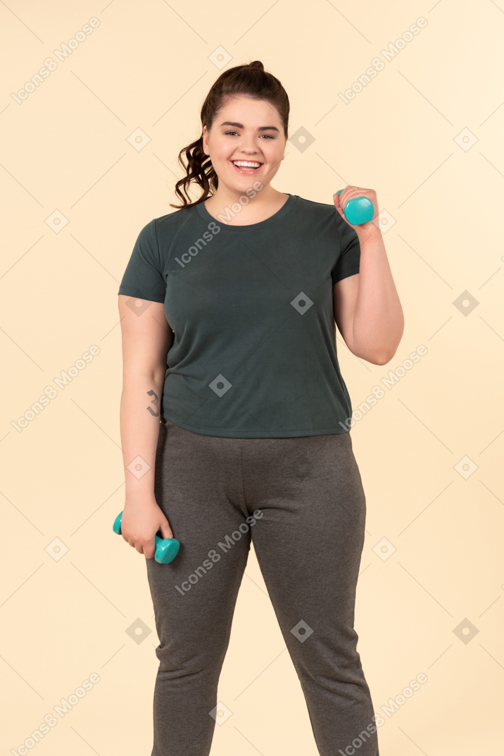 Young plus size woman in sport clothes doing physical exercises