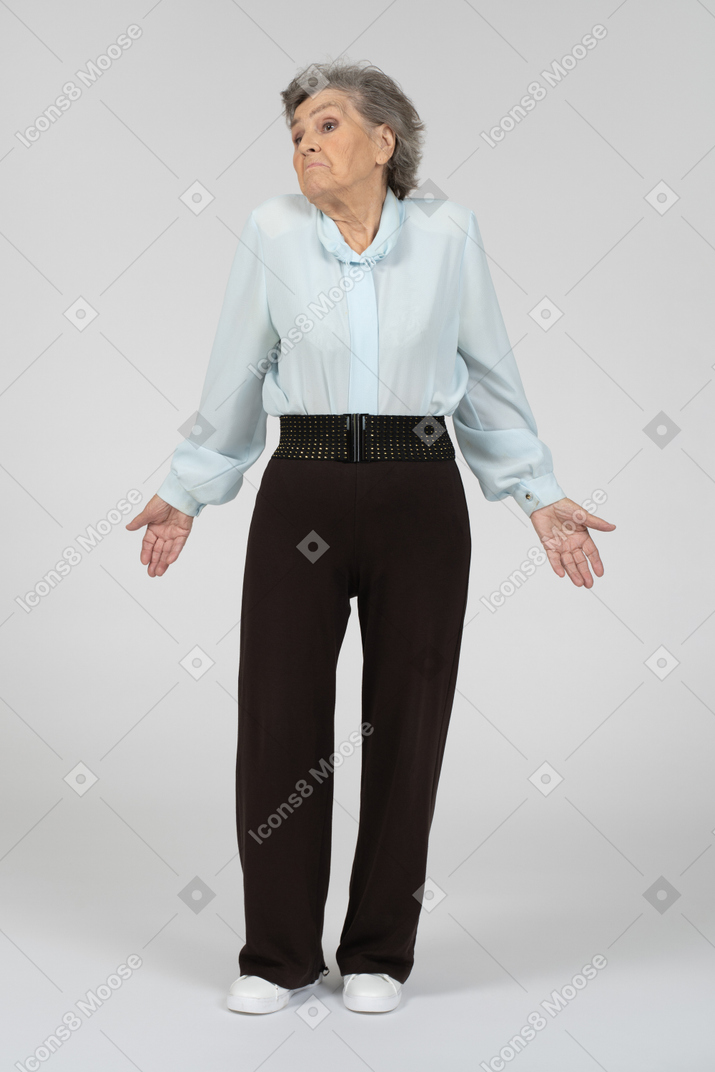 Vista frontal de una anciana encogiéndose de hombros y mirando a un lado
