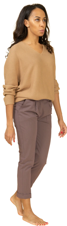 Three-quarter view of a young female in casual clothes walking