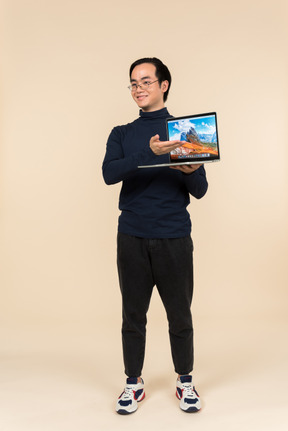 Young asian man presenting a laptop