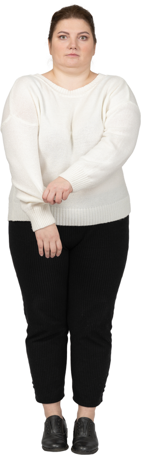 Vista frontal de una mujer de talla grande en ropa casual enrollando su manga