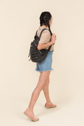 バックパックを持つ若い女性の背面図
