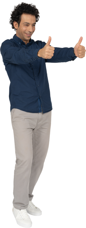 Vista frontal de um homem com roupas casuais mostrando os polegares para cima