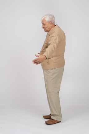 Vista lateral de um velho em roupas casuais em pé com os braços estendidos
