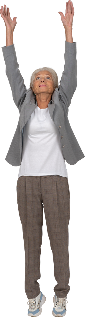 Vista frontale di una vecchia signora in abito in piedi con le braccia alzate