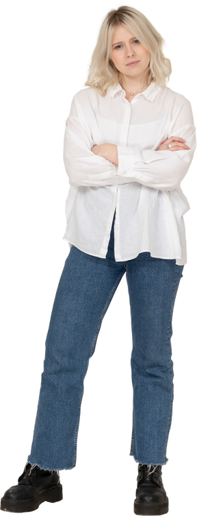Vista frontal de uma modelo loira feminina em roupas casuais, cruzando as mãos e olhando para a câmera