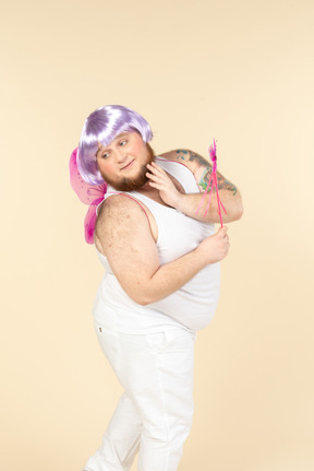 Dreamy young overweight man dressed as a fairy