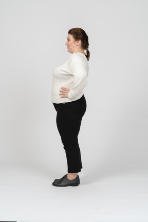 Side view of a plump woman in casual clothes posing