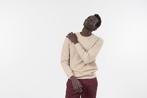 A young black man in a grey sweater standing alone on the white background