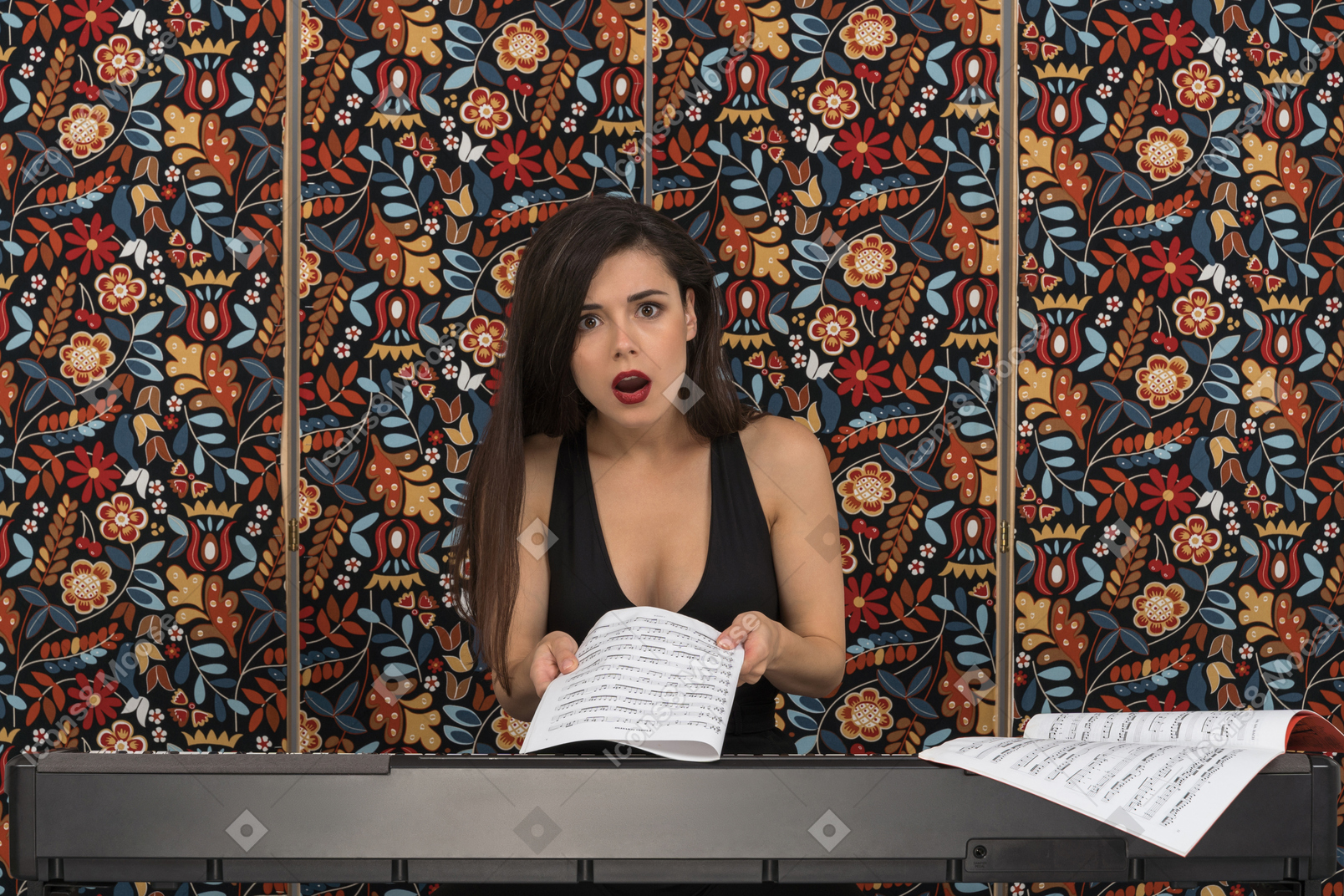 Portrait of a shocked female pianist holding a musical notation
