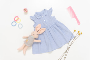 Kid girl's blue dress, stuffed toy, pink plastic hairbrush and accessories