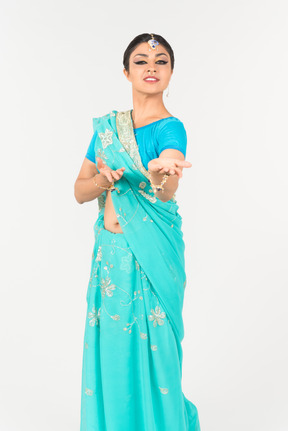 Jeune femme indienne en sari bleu debout en position de danse