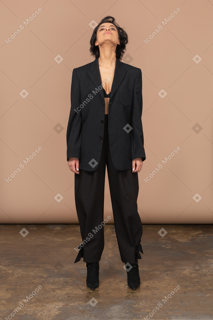 A woman in a black suit looking up
