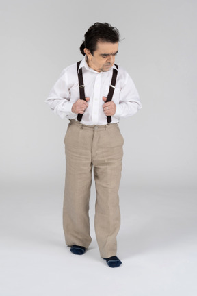 Middle-aged man holding suspenders