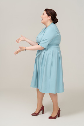 Happy woman in blue dress posing in profile