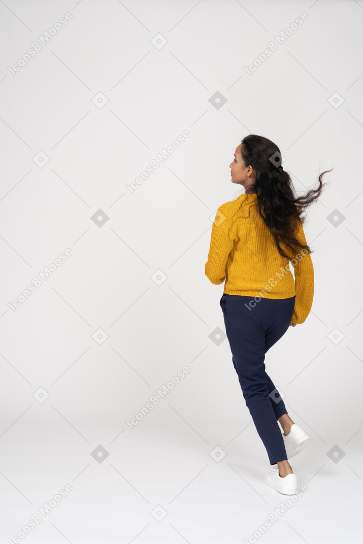 Rear view of a girl in casual clothes running
