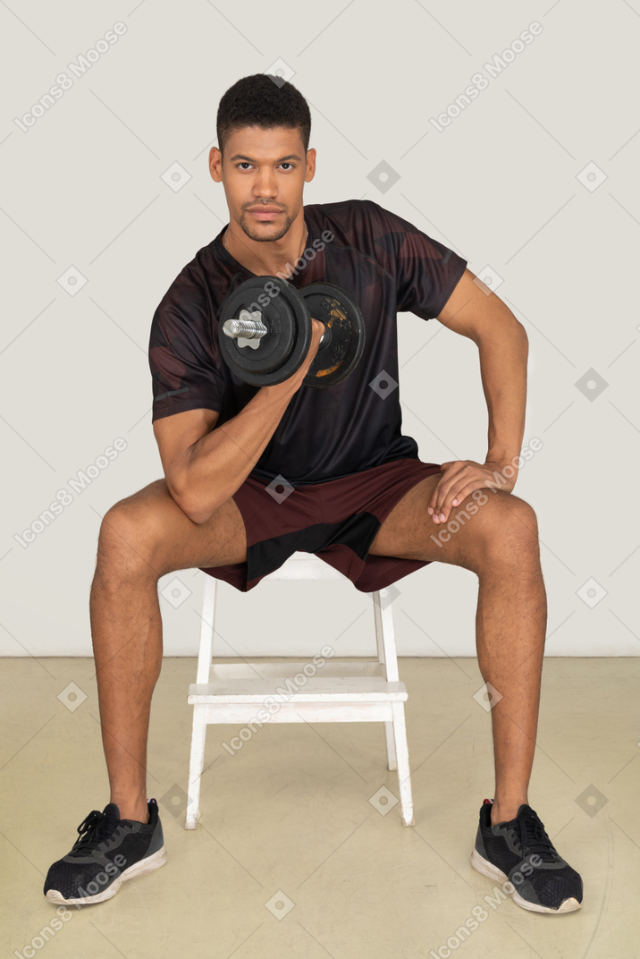 Young man in sports clothes lifting weights