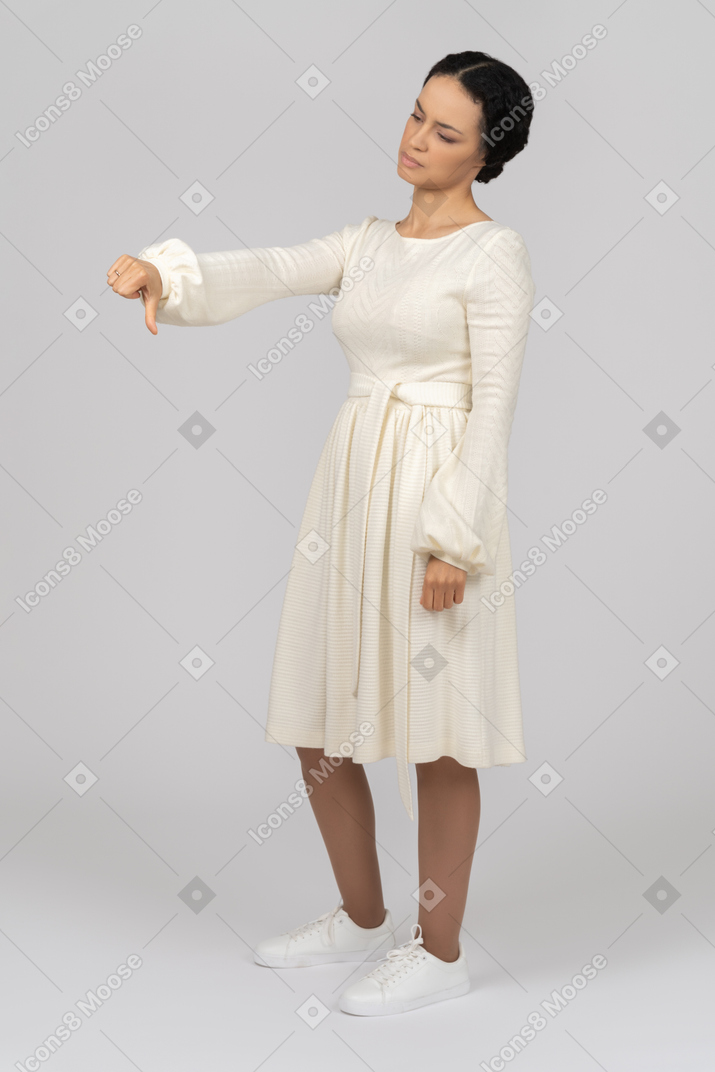 Disappointed young woman showing a thumb down