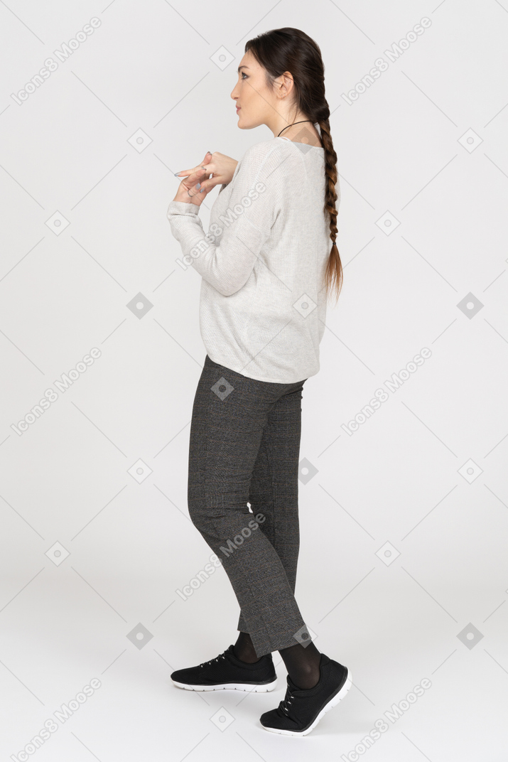 Slim young woman with a plait holding hands together
