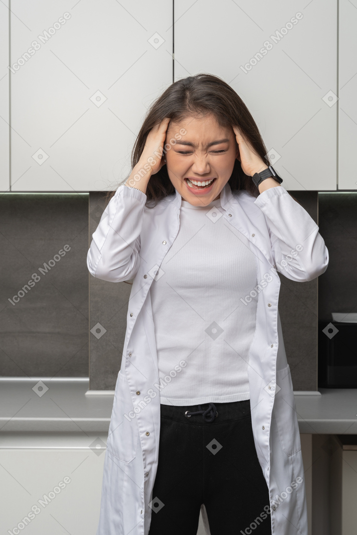 Front view of a female doctor with a headache
