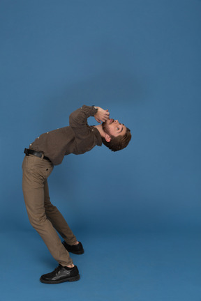 Slim young man doing gymnastic exercises