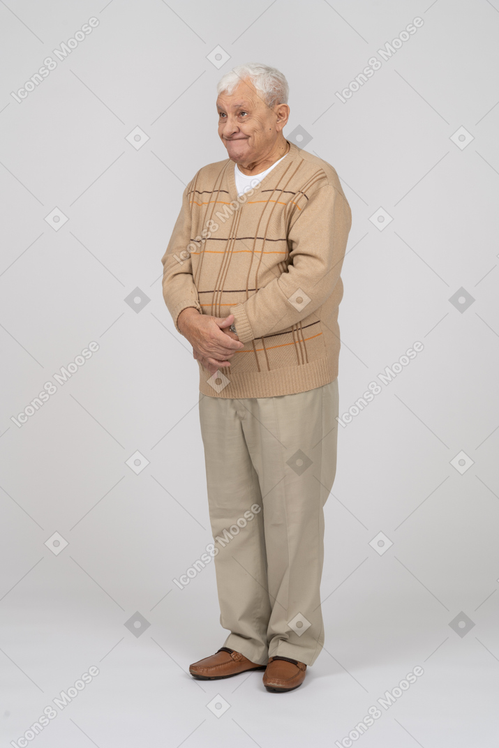 Vorderansicht eines glücklichen alten mannes in freizeitkleidung, der still steht