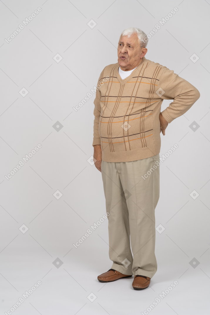 Front view of an old man suffering from back pain
