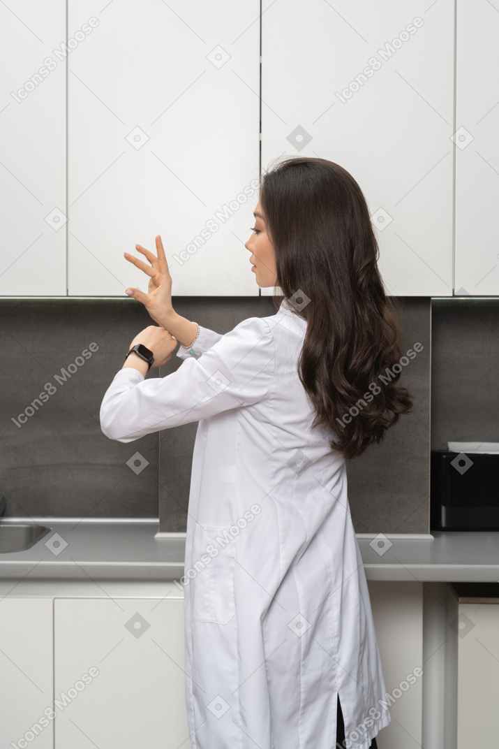 Young woman in lab coat using smart technology
