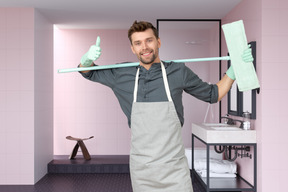 Man in apron cleaning the bathroom