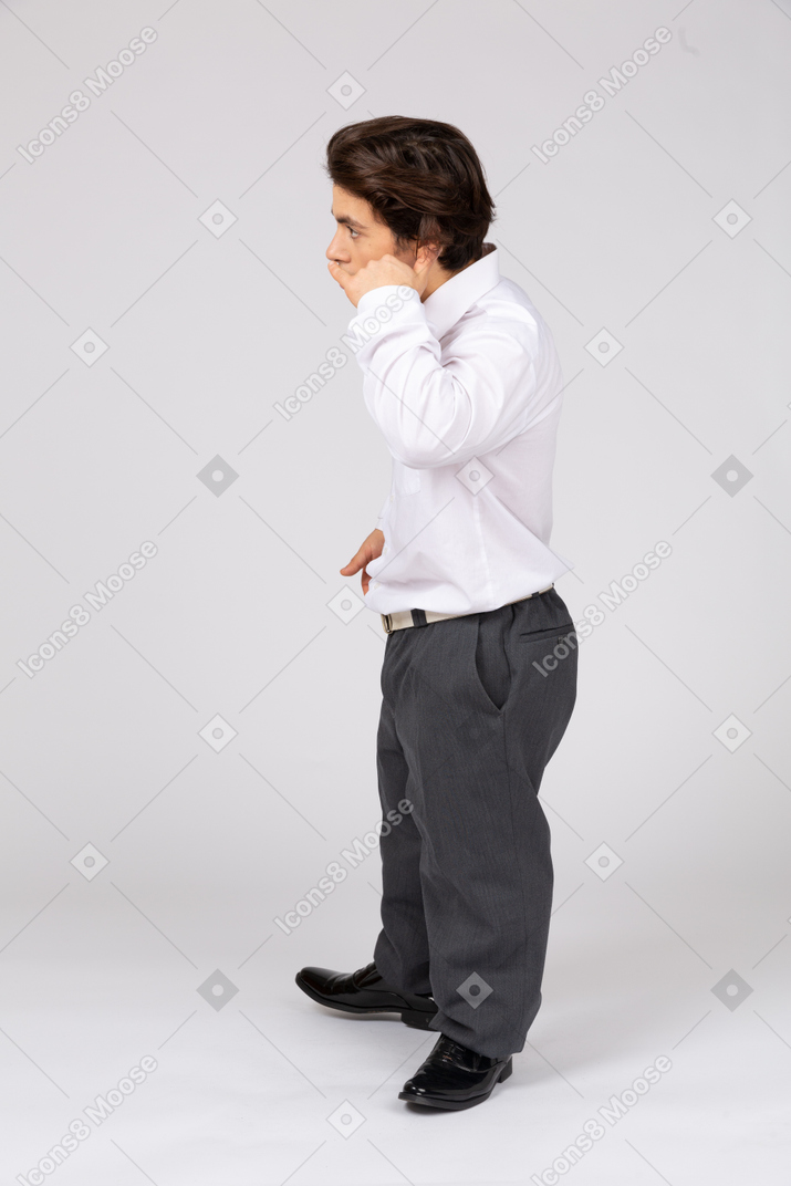 Side view of an office worker pretending to make a phone call