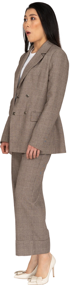 Three-quarter view of a surprised young lady in brown business suit