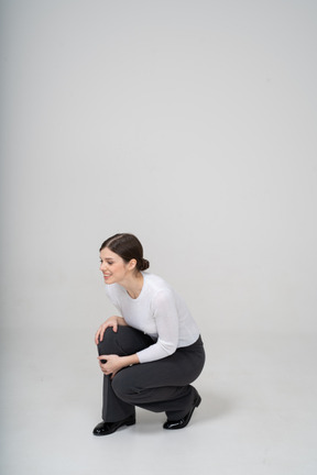 Front view of a young woman squatting