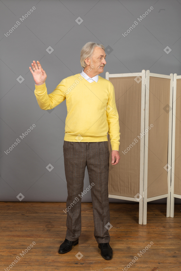 Front view of an old man raising his hand