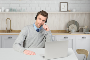 A man sitting at a table in front of a laptop computer