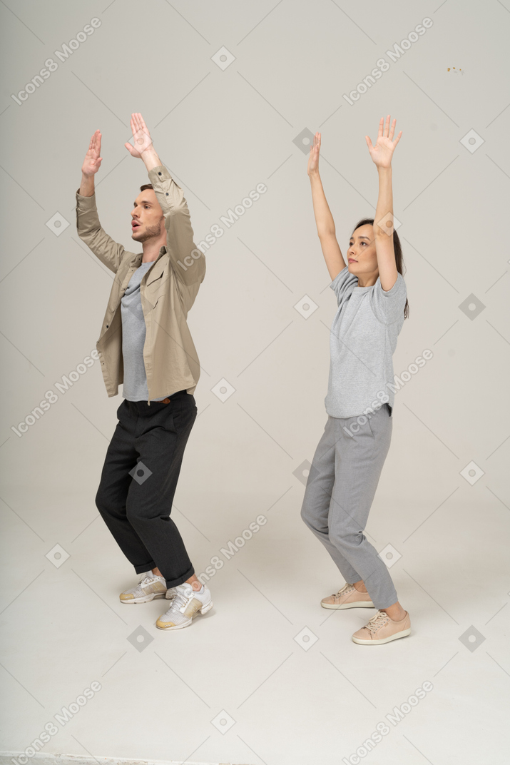 Three quarter view of young man and woman waving someone