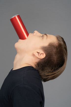 Seitenansicht eines männlichen aufsteigenden kopfes mit roter dose im mund