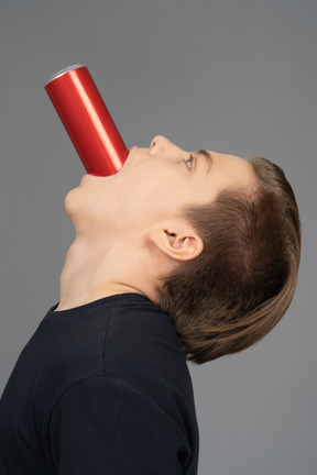 Side view of a male rising head with red can in his mouth