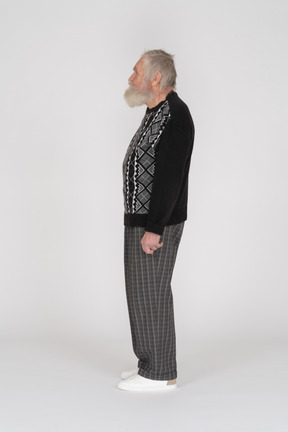 Vista lateral de um velho em pé de suéter preto