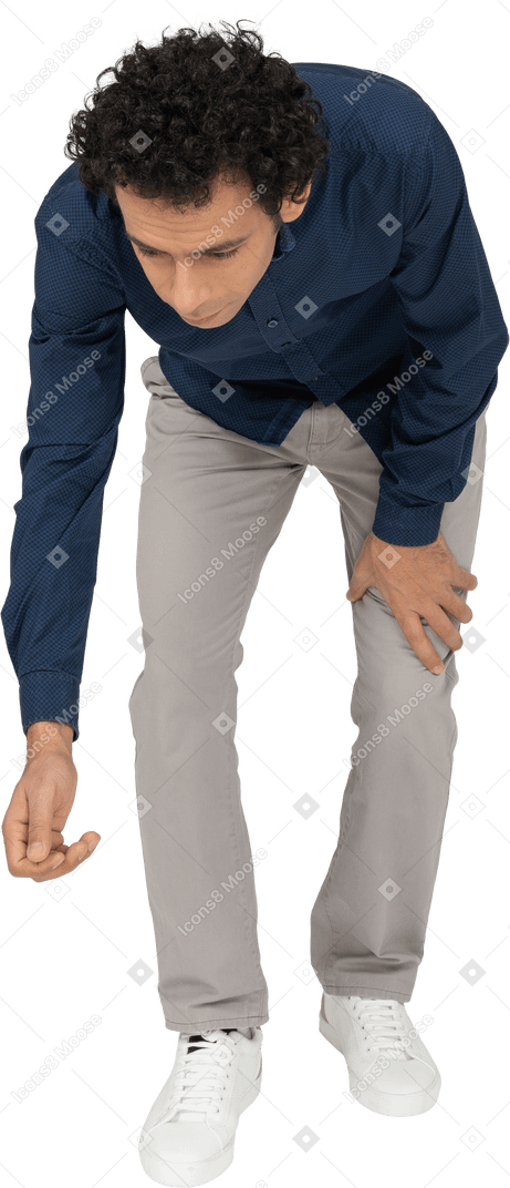 Front view of a man in casual clothes bending down