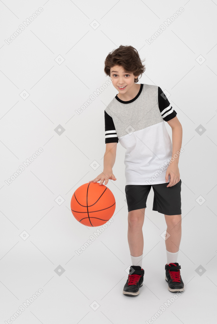 Junge, der einen basketballball schlägt