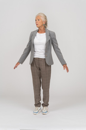 Vista frontale di una vecchia signora in abito in piedi sulle punte dei piedi e braccia aperte