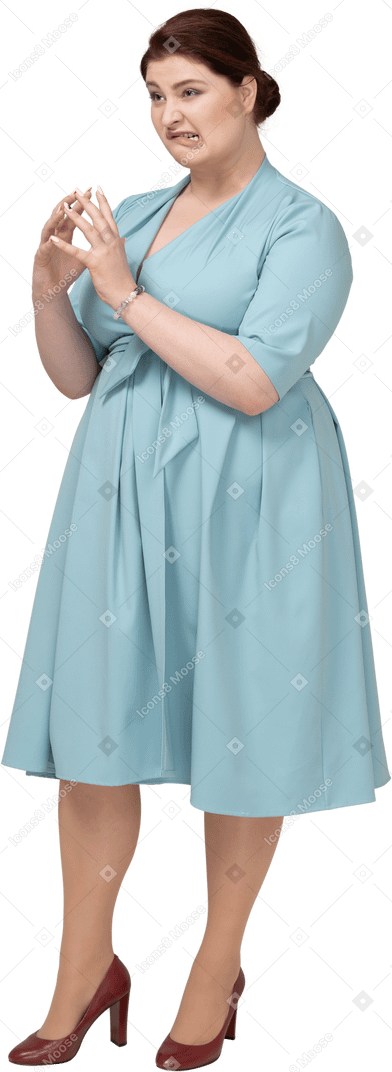 Front view of a woman in blue dress making faces