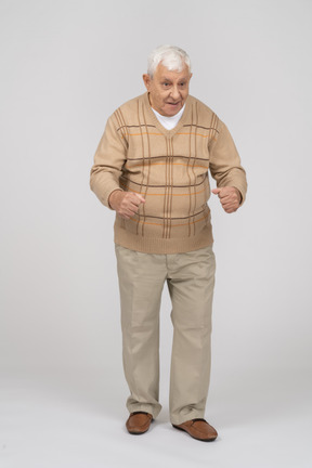 Vue de face d'un vieil homme heureux dans des vêtements décontractés expliquant quelque chose